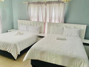 two beds sitting next to each other in a bedroom at Mabutane Villas in Badplaas