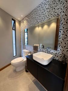 a bathroom with a sink and a toilet and a mirror at Casa con vista a cuenca in Cuenca