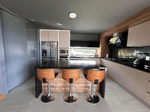 a kitchen with a black counter and some stools at Casa con vista a cuenca in Cuenca +15 photos