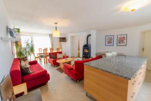 a kitchen and living room with red chairs and a table at Apartment FreiRaum in Innsbruck