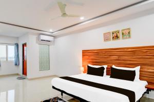 a bedroom with a large bed with a wooden headboard at Hotel O Inn In Town in Sangāreddi +23 photos
