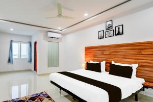 a bedroom with a large bed with a wooden headboard at Hotel O Inn In Town in Sangāreddi