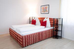 a bed with red and white pillows in a room at Apartment FreiRaum in Innsbruck
