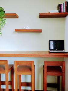 a counter with two stools and a laptop on it at La Casa de Lu cerca de Volcanic park in San Martín Ojo de Agua