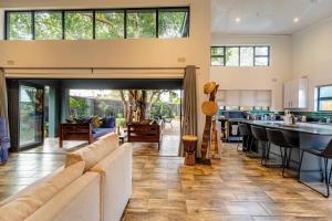 a living room with a couch and a kitchen at Wild Villas in Victoria Falls