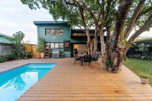 a house with a pool and a table and chairs at Wild Villas in Victoria Falls