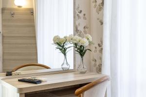 a table with two vases with white flowers on it at Hotel Welt in Gatteo a Mare