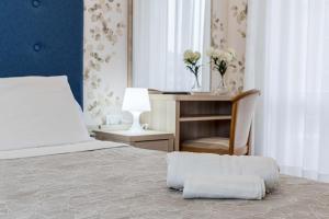 a bedroom with a bed with a desk and a chair at Hotel Welt in Gatteo a Mare
