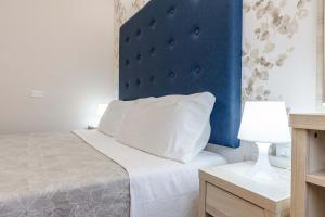 a bedroom with a bed with a blue headboard at Hotel Welt in Gatteo a Mare