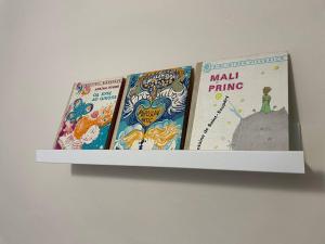 three books sitting on a shelf on a wall at House1890 in Kula