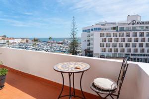 a table and chairs on a balcony with a view of a city at Marine Freestyler Glorious Terrace in Faro