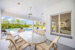 a dining room with a table and chairs and a pool at SWISS 101 - Lake Olsen in Clermont