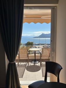 a room with a view of the ocean from a balcony at Palatino in Loutra Edipsou