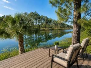 a wooden deck with two chairs and a table next to a river at SWISS 28 - Lake Stephanie in Clermont