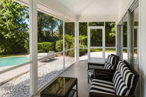 a screened in porch with chairs and a pool at SWISS 28 - Lake Stephanie in Clermont