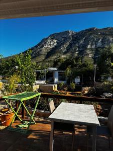 a patio with a table and a mountain in the background at Casa Raíces del Montgo in Denia