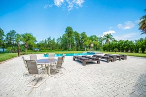 a patio with a table and chairs next to a pool at SWISS 105 - Lake Olsen in Clermont