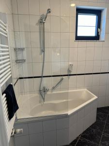 a bath tub with a shower in a bathroom at Hotel Pommerloch in Pommerloch +44 photos