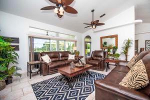 a living room with leather furniture and a ceiling fan at SWISS 56 - Lake Denise in Clermont