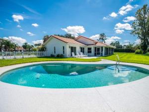 a house with a swimming pool in front of a house at SWISS 14 - Lake Stephanie in Clermont