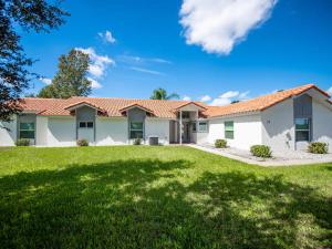 a house with a green lawn in front of it at SWISS 14 - Lake Stephanie in Clermont
