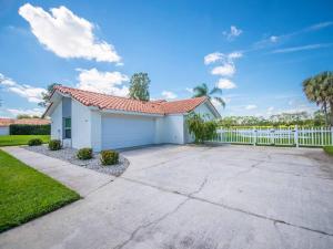 a house with a white fence and a driveway at SWISS 14 - Lake Stephanie in Clermont