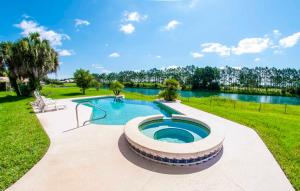 a swimming pool in a grassy area with a lake at SWISS 61 - Lake Denise in Clermont