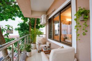 a balcony with chairs and a table and some plants at Ocean n' Sand - By Q23 Resorts & Suites in Candolim