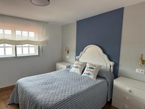 a blue bedroom with a bed with two pillows at BOA VISTA in Combarro