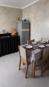a kitchen with a table with chairs and a refrigerator at Casa Tranquila com Vaga para carro em Três Lagoas in Três Lagoas