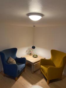 a living room with two chairs and a wooden table at Værelse med eget køkken og bad in Esbjerg