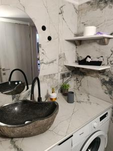 a bathroom with a black sink and a washing machine at liana house 3 in Skála Loutrón +22 photos