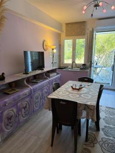 a kitchen with a table and a tv on the wall at liana house 3 in Skála Loutrón