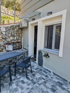 a patio with a table and chairs next to a building at liana house 3 in Skála Loutrón