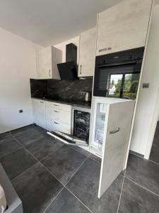 a kitchen with white cabinets and an open refrigerator at Modernes 1-Zimmer Apartment mit Küche und Bad in Merzig +8 photos