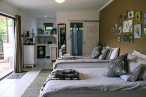 three beds in a room with a kitchen at Canary Cottage in Greyton