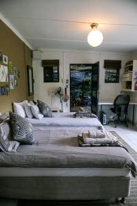 a large bed in a bedroom with a lamp at Canary Cottage in Greyton