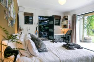a bedroom with a bed with pillows and a desk at Canary Cottage in Greyton