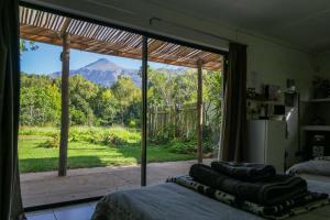 a bedroom with a large window with a view of a mountain at Canary Cottage in Greyton