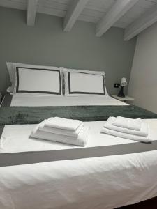 a white bed with white towels on top of it at Studio21 Monza in Monza