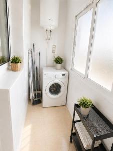 a laundry room with a washing machine and a window at La Riviera Residence in Rojales +3 photos
