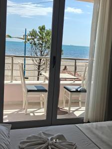 a bedroom with a view of the beach from a balcony at SeaView Vacation Rooms in Durrës