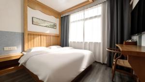 a large white bed in a room with a window at Breeze Alley Inn-English services-3mins walk to Park-12mins to Hub-Breakfast,Coffee,Laundry&Tickets in Zhangjiajie