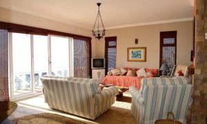 a living room with two chairs and a couch at Oceanview Sunrise Beach Villa in Rocklands