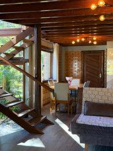 a living room with a wooden staircase and a table at Refugio Poço do Cânion in Alfredo Wagner
