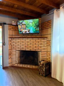 a living room with a fireplace with a flat screen tv at Refugio Poço do Cânion in Alfredo Wagner