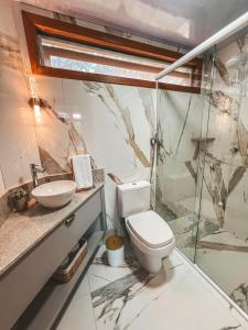 a bathroom with a toilet and a sink at Refugio Poço do Cânion in Alfredo Wagner +56 photos