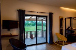 a room with a sliding glass door with a balcony at Zenery Lake Resort in Ban Don Klang