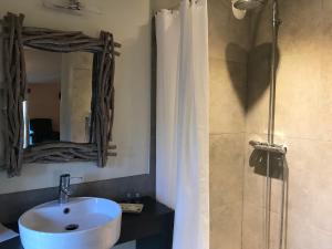 a bathroom with a sink and a shower with a mirror at La Mouline de Belin in Lectoure +22 photos