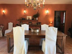 a dining room with a wooden table and white chairs at La Mouline de Belin in Lectoure